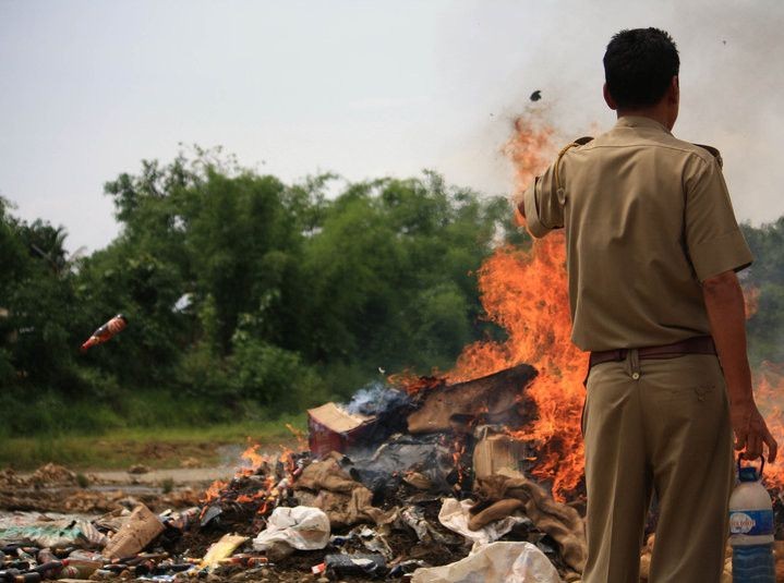 BURNING ISSUE: An enforcement personnel watches over destruction of seized liquor in Nagaland. Around thirty-four years since its enactment, the Nagaland Liquor Total Prohibition Act (NLTP) 1989 continues to be a contentious issue in the State. (Morung File Photo)